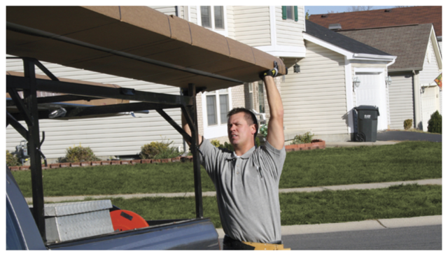 Man lifting a garage door onto a truck
